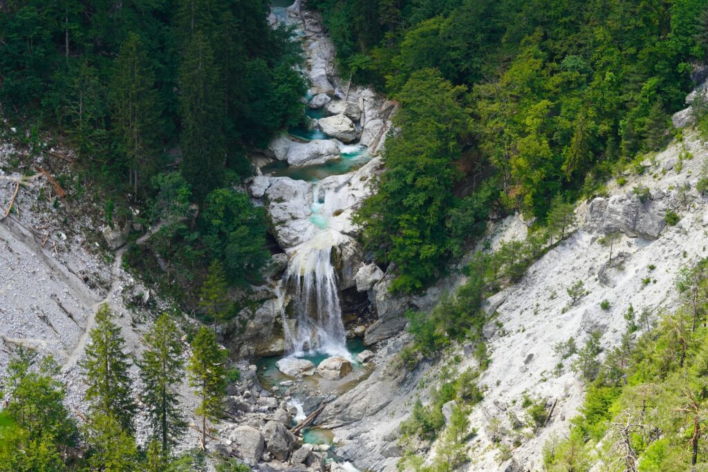 waterfalls in the middle of green trees