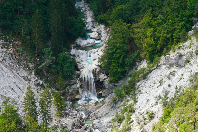 waterfalls in the middle of green trees